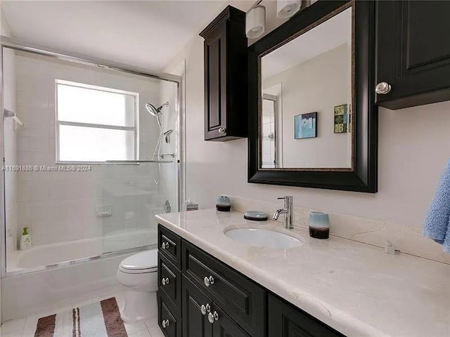 full bathroom with tiled shower / bath, tile patterned floors, toilet, and vanity