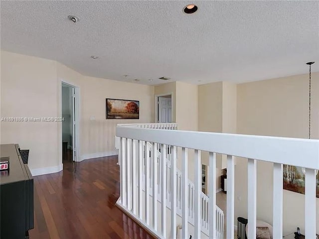 hall featuring dark hardwood / wood-style flooring and a textured ceiling