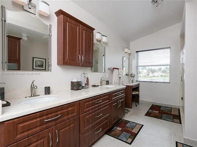 bathroom with vanity, a shower with door, tile patterned flooring, and vaulted ceiling