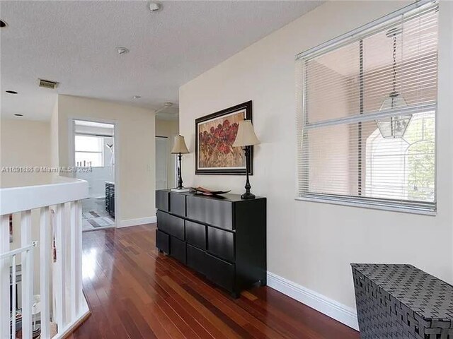 hallway featuring dark hardwood / wood-style flooring and a textured ceiling