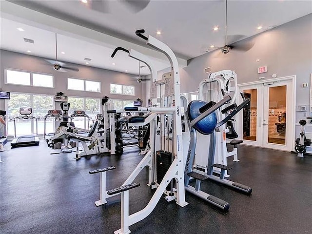 gym featuring plenty of natural light, ceiling fan, and a high ceiling