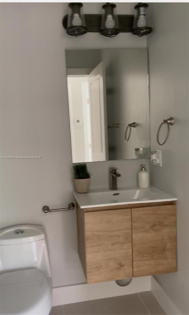 bathroom featuring tile patterned flooring, vanity, and toilet