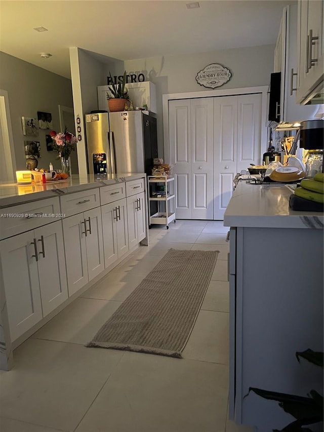 kitchen featuring white cabinets and light tile patterned flooring