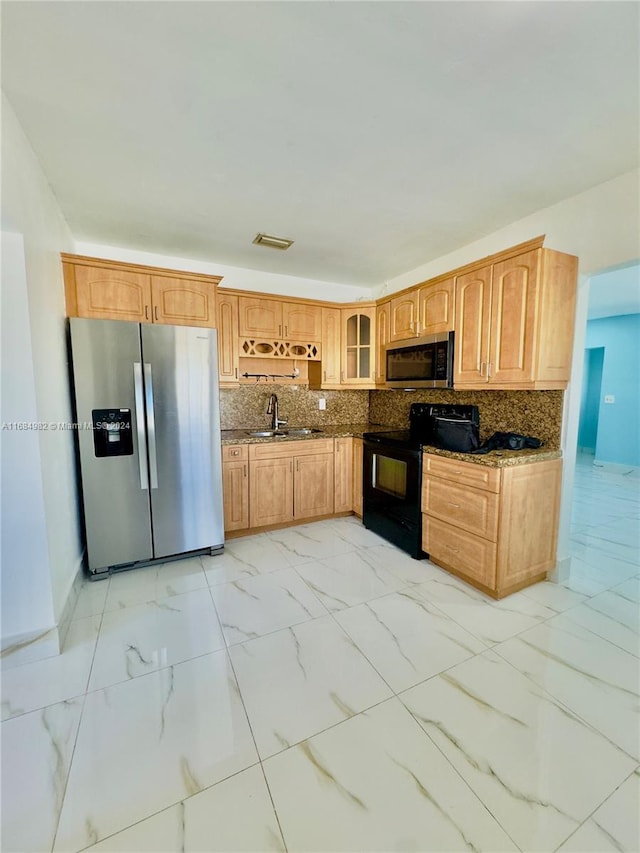 kitchen with dark stone countertops, sink, appliances with stainless steel finishes, and tasteful backsplash