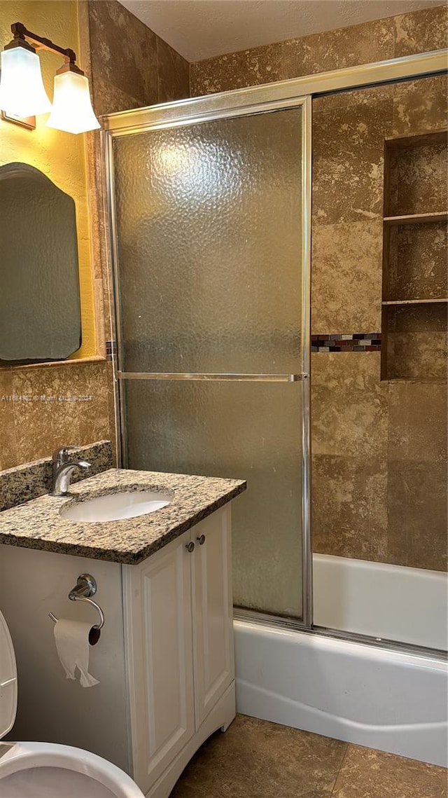 full bathroom with tile patterned floors, vanity, toilet, and enclosed tub / shower combo