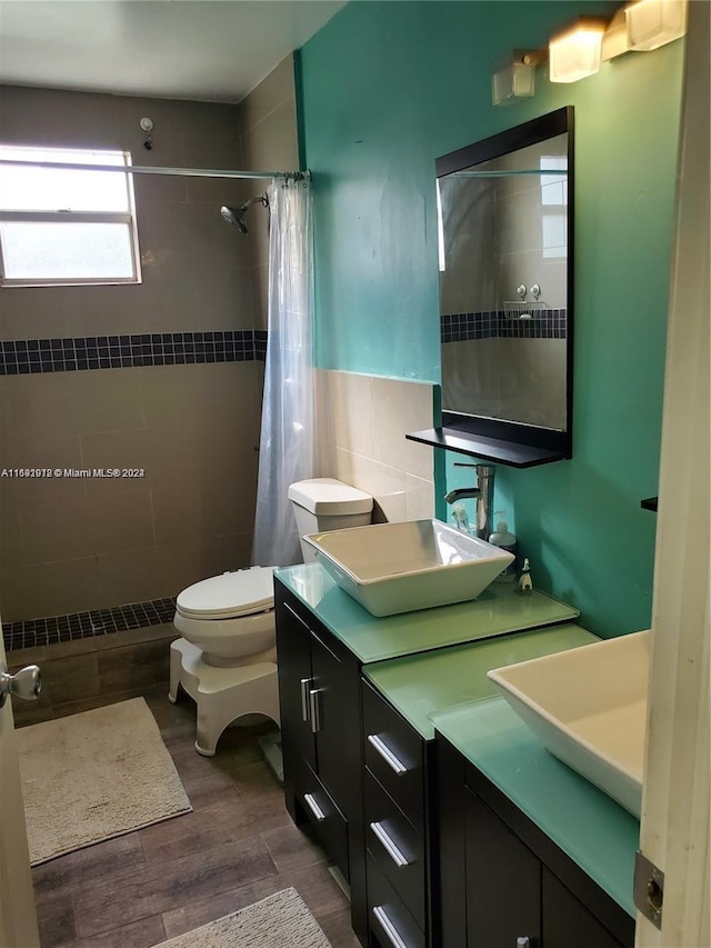 bathroom with walk in shower, vanity, hardwood / wood-style floors, and tile walls