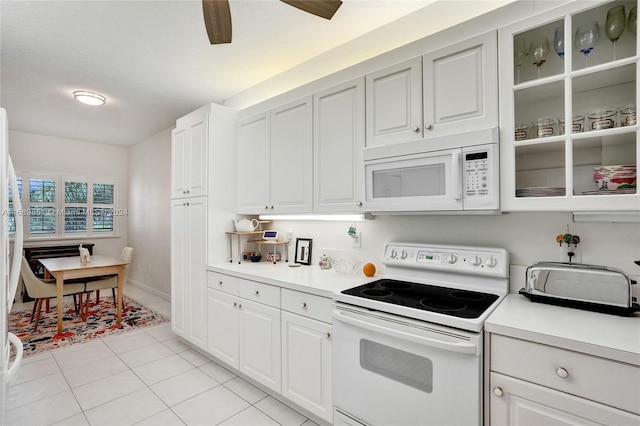 kitchen with white cabinetry, light tile patterned flooring, and white appliances