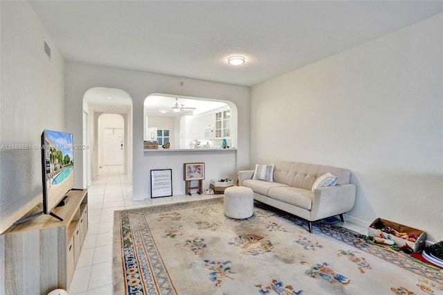 tiled living room with ceiling fan