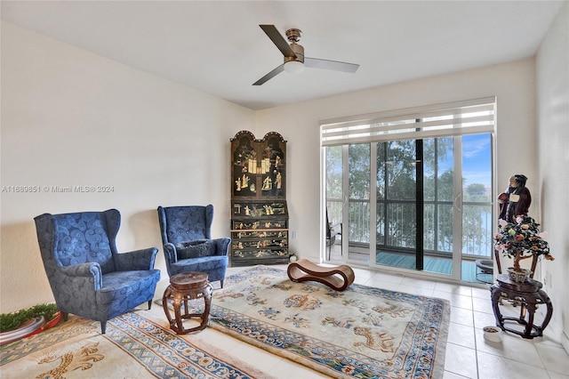 living area with ceiling fan and tile patterned flooring