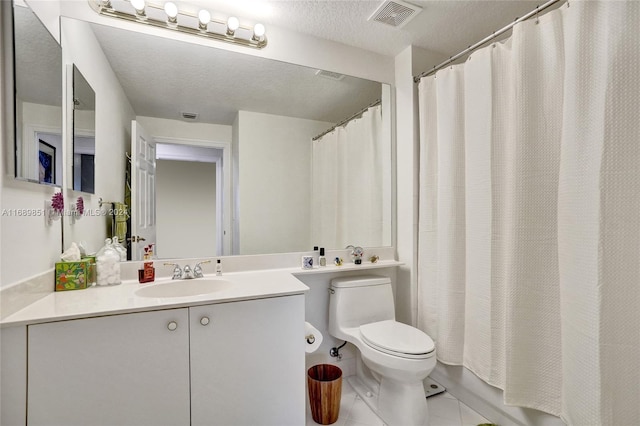 full bathroom with tile patterned floors, vanity, a textured ceiling, shower / bath combo with shower curtain, and toilet