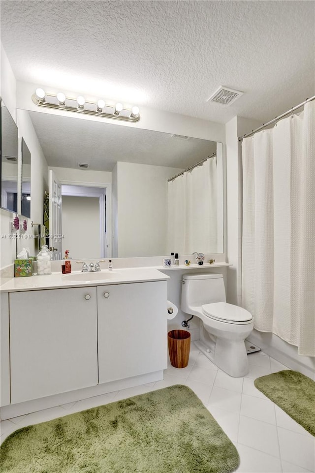 full bathroom with tile patterned floors, vanity, a textured ceiling, and toilet