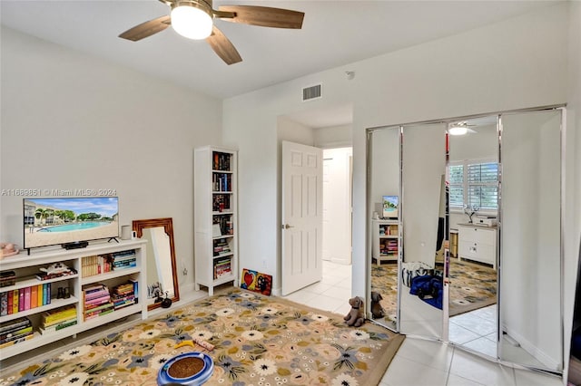 bedroom with ceiling fan, a closet, and light tile patterned floors