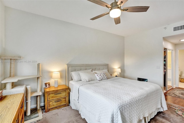 bedroom featuring connected bathroom, ceiling fan, a closet, and wood-type flooring