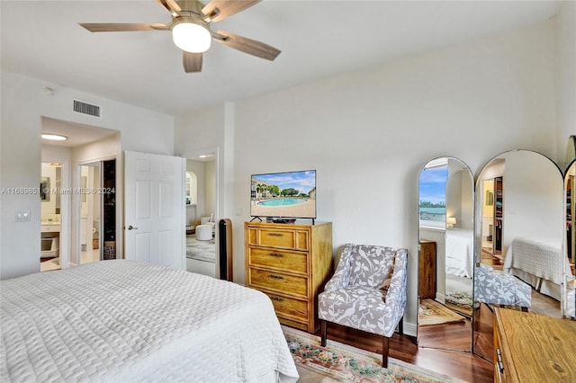 bedroom with ensuite bath, ceiling fan, and hardwood / wood-style floors