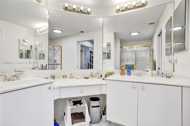 bathroom with tile patterned floors, vanity, and a shower with door