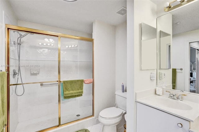 bathroom featuring tile patterned floors, toilet, vanity, and walk in shower