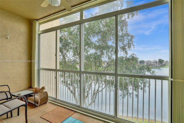 sunroom with a water view, plenty of natural light, and ceiling fan