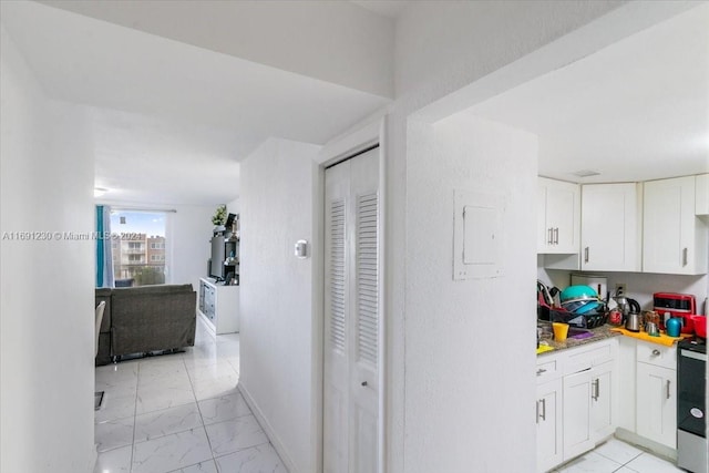 kitchen featuring electric range oven and white cabinets