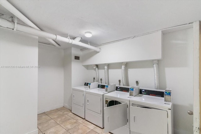 washroom featuring washing machine and dryer and light tile patterned flooring