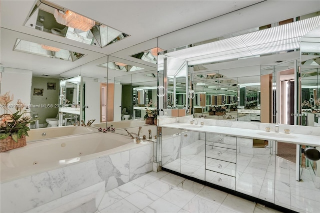 bathroom with vanity, toilet, and tiled tub