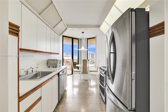 kitchen with white cabinets, appliances with stainless steel finishes, pendant lighting, and sink