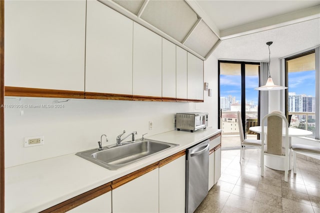 kitchen featuring dishwasher, white cabinetry, hanging light fixtures, and sink