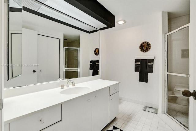 bathroom with toilet, vanity, tile patterned floors, and an enclosed shower