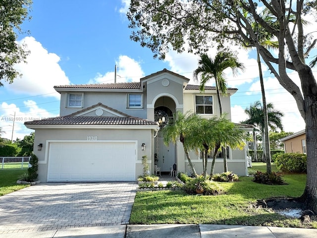 mediterranean / spanish-style house featuring a garage and a front yard