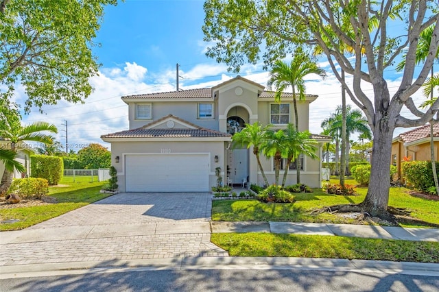 mediterranean / spanish-style home featuring a garage and a front lawn