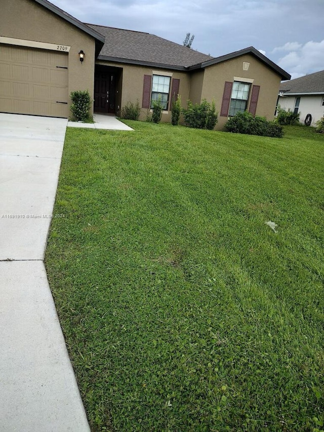 ranch-style home featuring a garage and a front yard