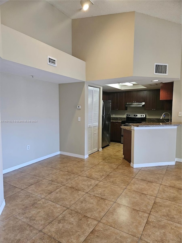 kitchen featuring sink, kitchen peninsula, appliances with stainless steel finishes, high vaulted ceiling, and dark brown cabinets