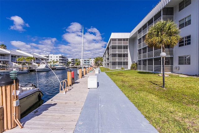 view of dock with a yard and a water view