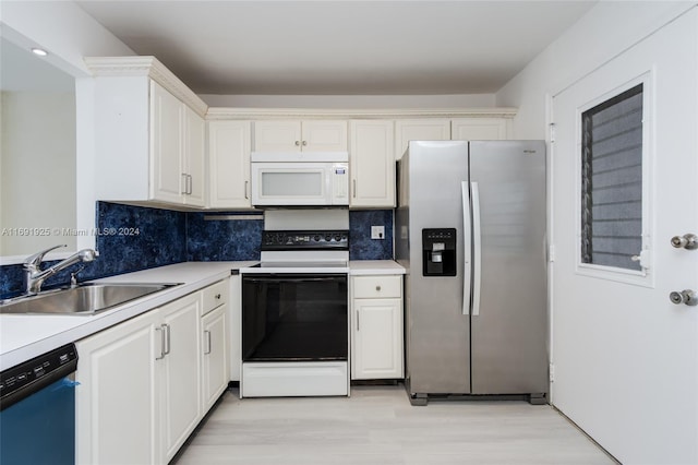 kitchen with white cabinetry, white appliances, and sink