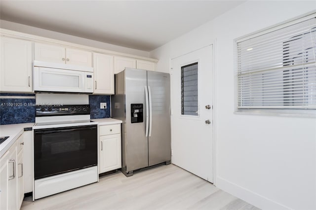 kitchen featuring light wood-type flooring, backsplash, white appliances, and white cabinets