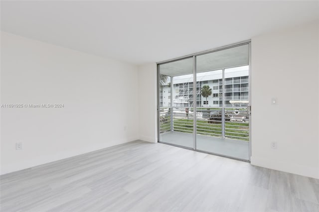 empty room with expansive windows and light wood-type flooring