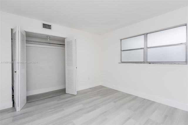 unfurnished bedroom featuring a closet and light hardwood / wood-style flooring