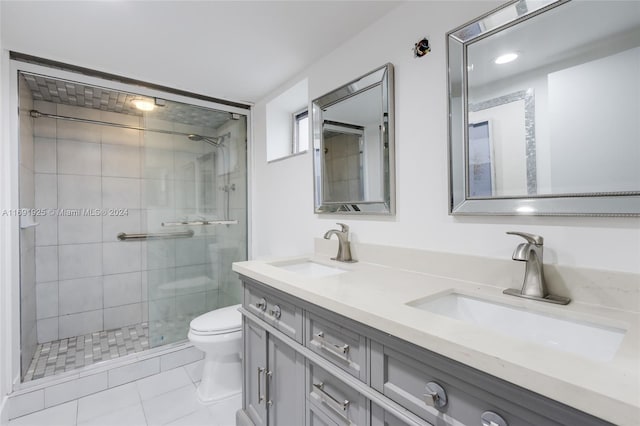 bathroom with vanity, tile patterned flooring, toilet, and an enclosed shower