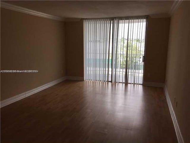 empty room featuring hardwood / wood-style floors and crown molding