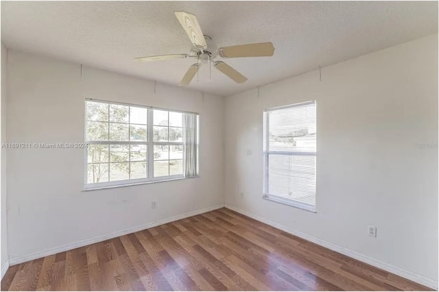 empty room featuring ceiling fan, a textured ceiling, and light hardwood / wood-style flooring