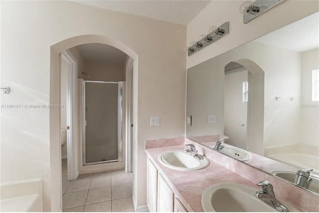 full bathroom featuring tile patterned flooring, a textured ceiling, vanity, shower with separate bathtub, and toilet