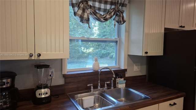 kitchen featuring white cabinetry, sink, and dark wood-type flooring