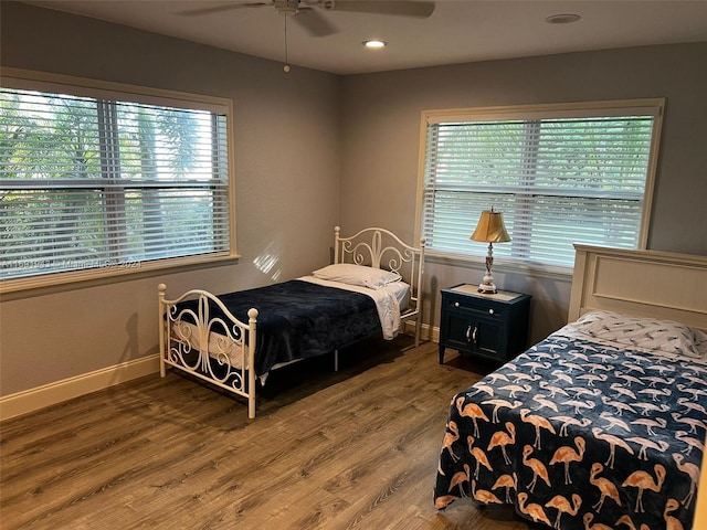 bedroom with hardwood / wood-style flooring, multiple windows, and ceiling fan