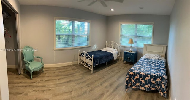 bedroom with a closet, hardwood / wood-style flooring, ceiling fan, and lofted ceiling