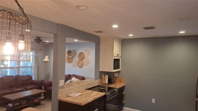 kitchen with electric stove, white cabinetry, ceiling fan, and black microwave