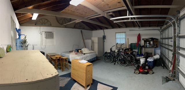 garage with white fridge and a wall unit AC