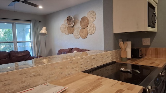 kitchen featuring butcher block countertops, ceiling fan, and stainless steel range with electric cooktop