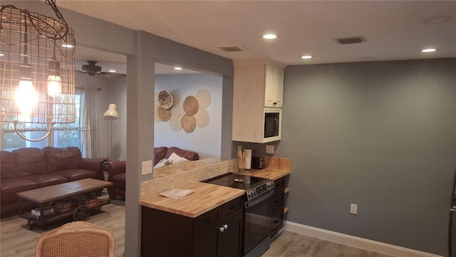 kitchen with white cabinets, light hardwood / wood-style floors, ceiling fan, and black appliances