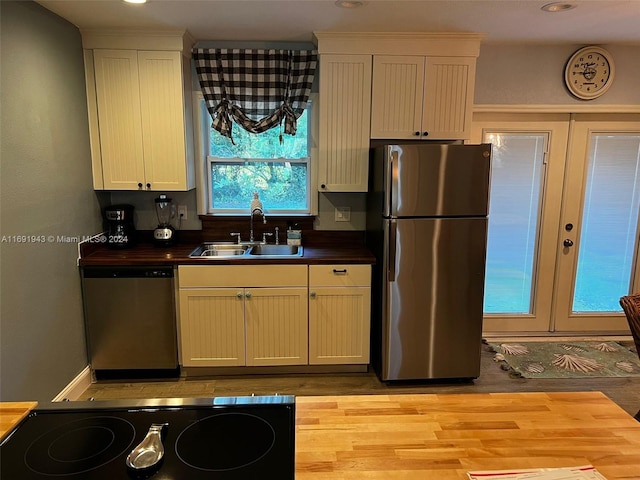 kitchen featuring white cabinetry, sink, light wood-type flooring, and appliances with stainless steel finishes