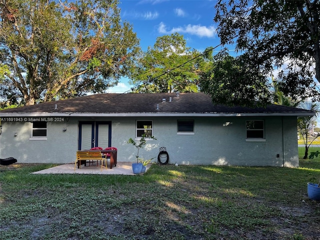 rear view of property featuring french doors, a yard, and a patio area