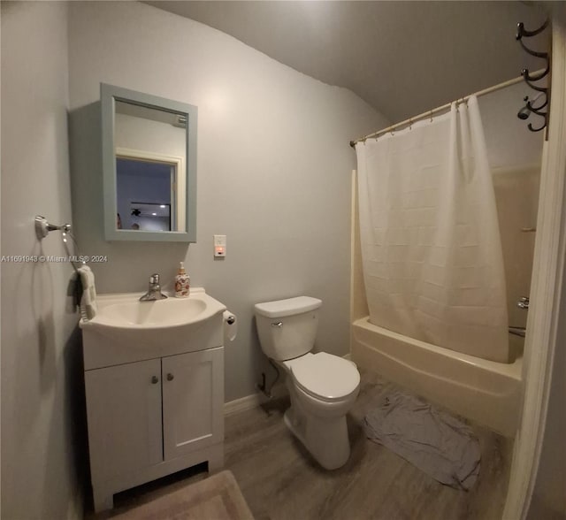 full bathroom featuring vanity, shower / tub combo with curtain, wood-type flooring, toilet, and lofted ceiling